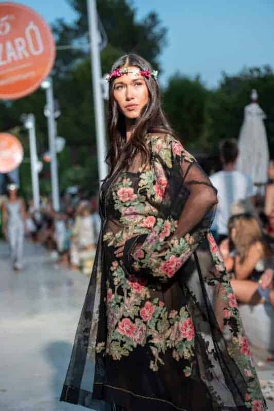 Beautiful woman wearing floral embroidered dress enjoying La Galeria Elefante Ibiza - Atzaro fashion show Ibiza