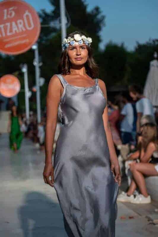 Stylish woman modeling grey silk dress with floral headpiece for La Galeria Elefante at Atzaro fashion show