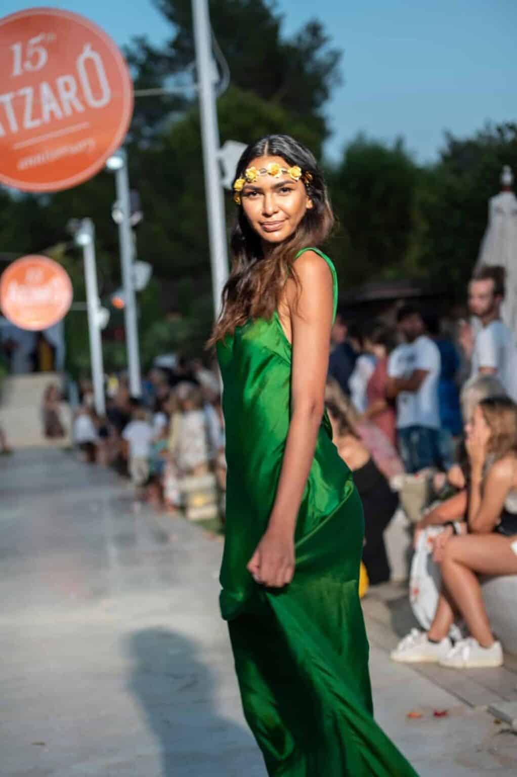Stylish woman in green dress with floral headband atLa Galeria Elefante Ibiza - Atzaro fashion show Ibiza