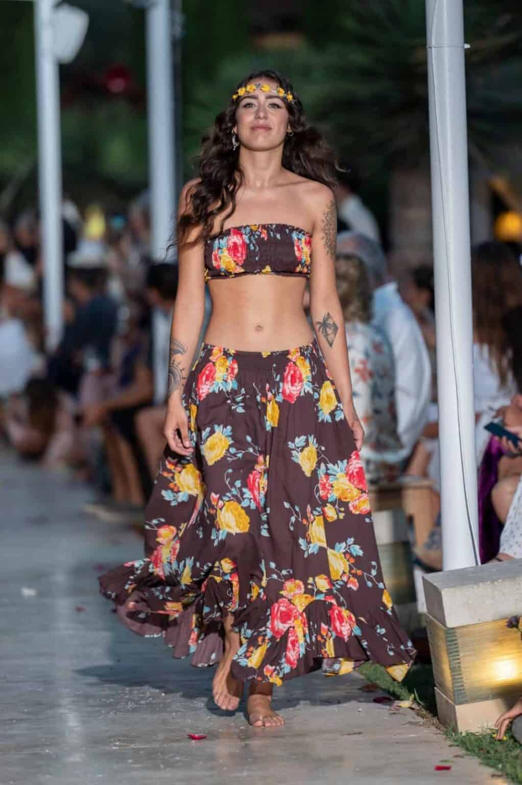 Woman wearing floral swimsuit at La Galeria Elefante fashion event showcasing summer styles.