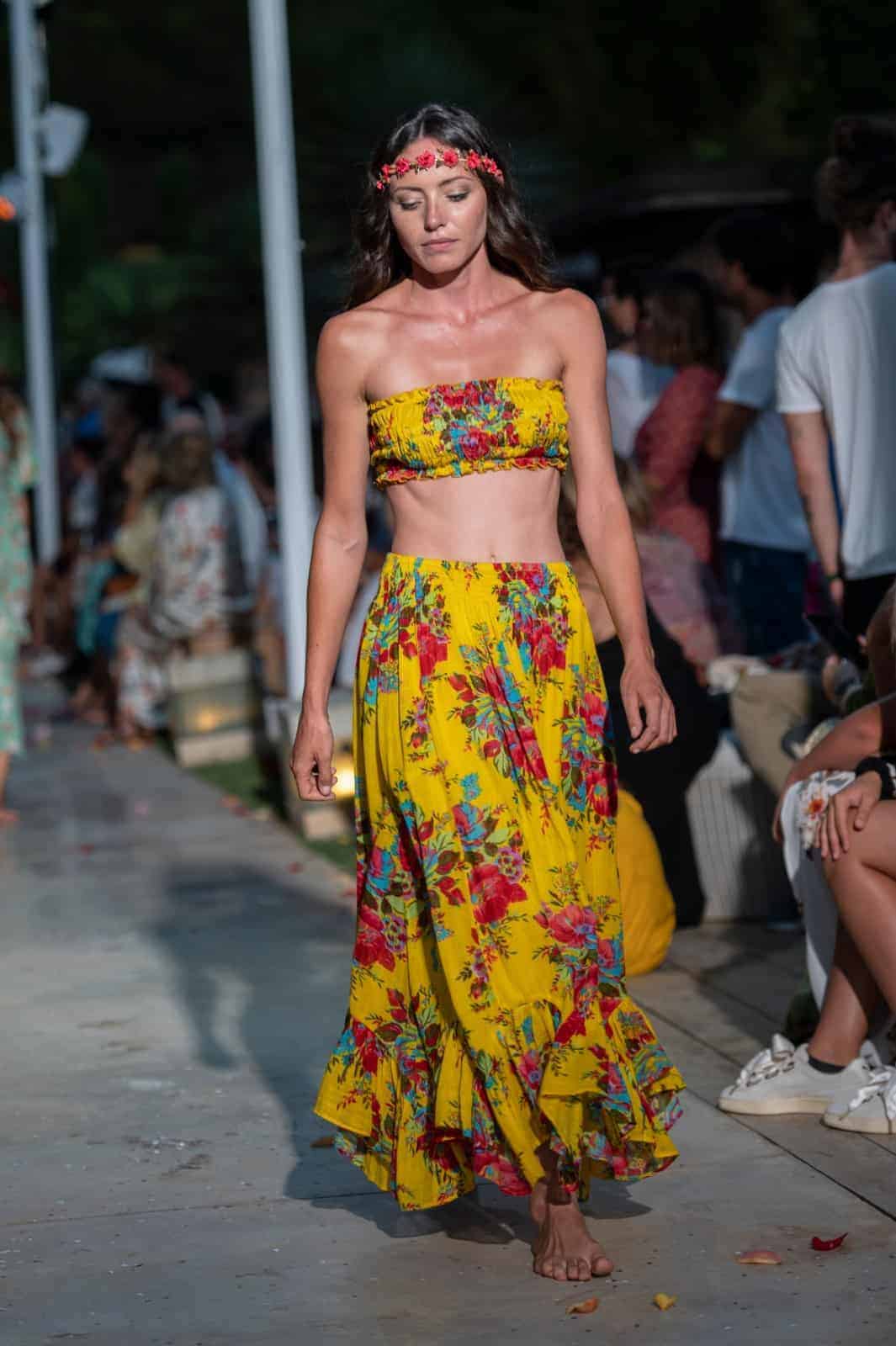 Elegant model wearing vibrant yellow floral outfit on runway at La Galeria Elefante Ibiza - Atzaro fashion show Ibiza
