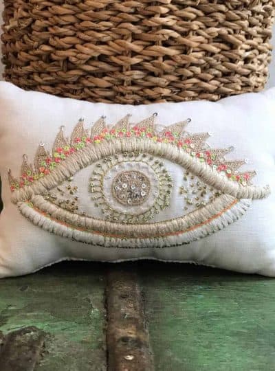 cushion filled with lavender with a multi coloured eye embroidered on it