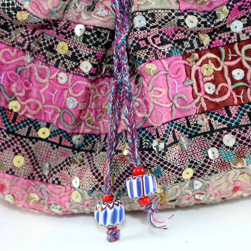 Bright pink, black, and multicolor embroidery with decorative pompoms, A detailed view of the intricate embroidery, sequins, and handcrafted embellishments at La Galeria Elefante.