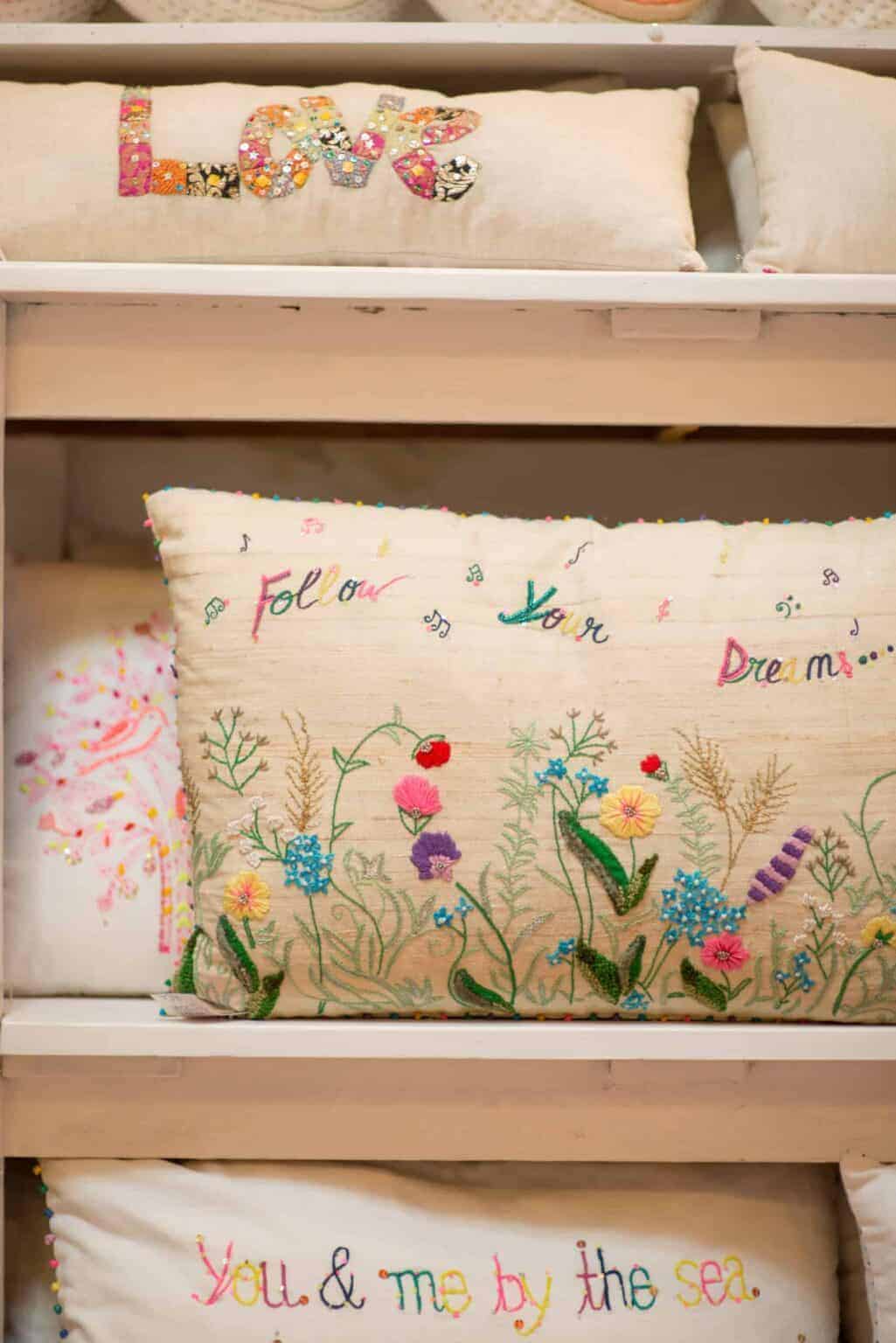 Vibrant embroidered cushions with floral and inspirational designs at La Galeria Elefante Ibiza