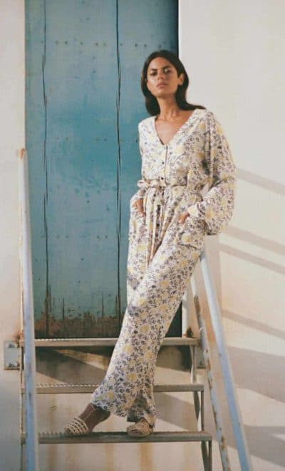 front view of a long sleeve jumpsuit in white with a yellow vine print side view