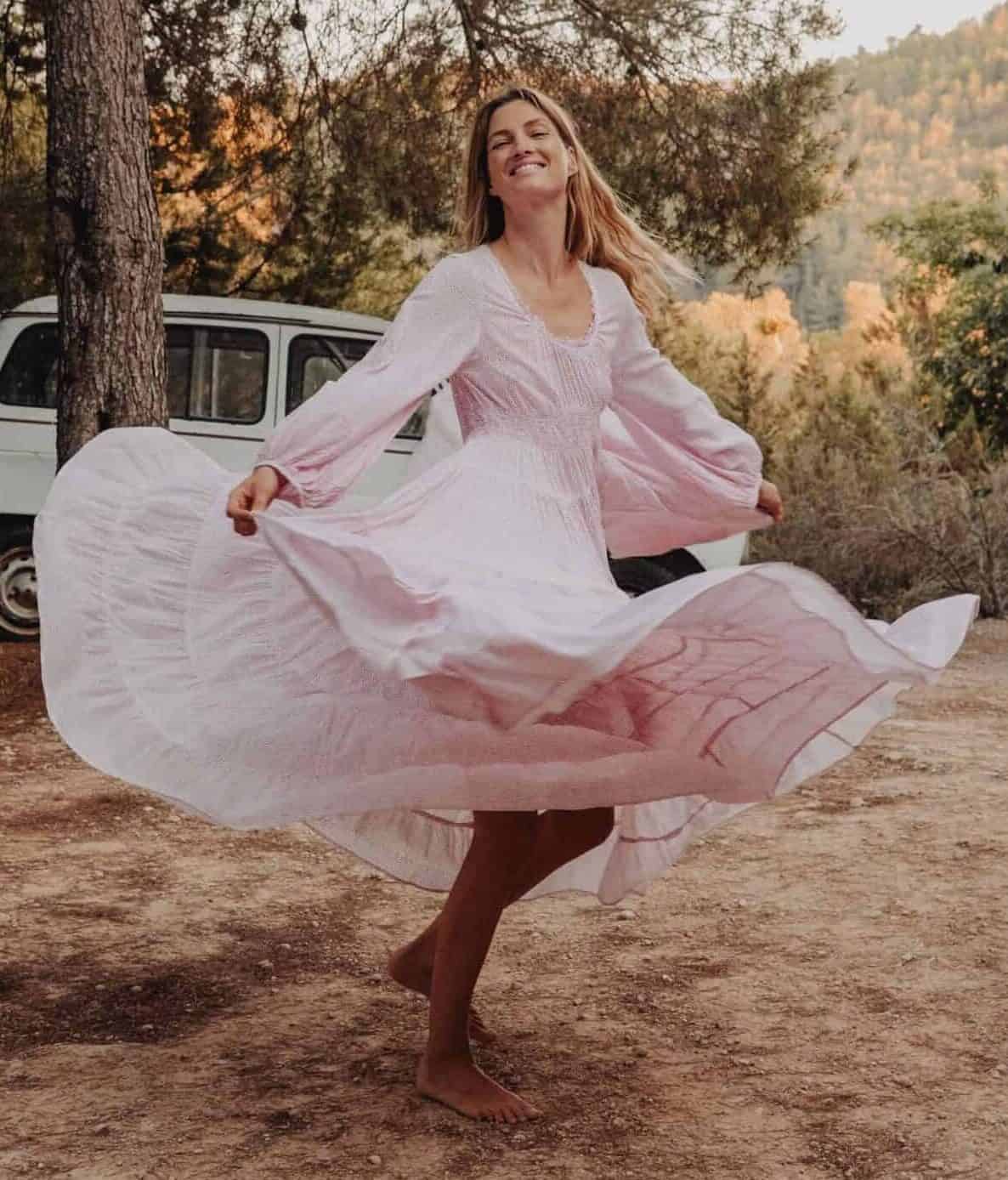 Elegant woman dancing in flowing pink dress outdoors La Galeria Elefante Ibiza - Atzaro fashion show Ibiza