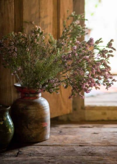 wooden vase filled with pink heather branches