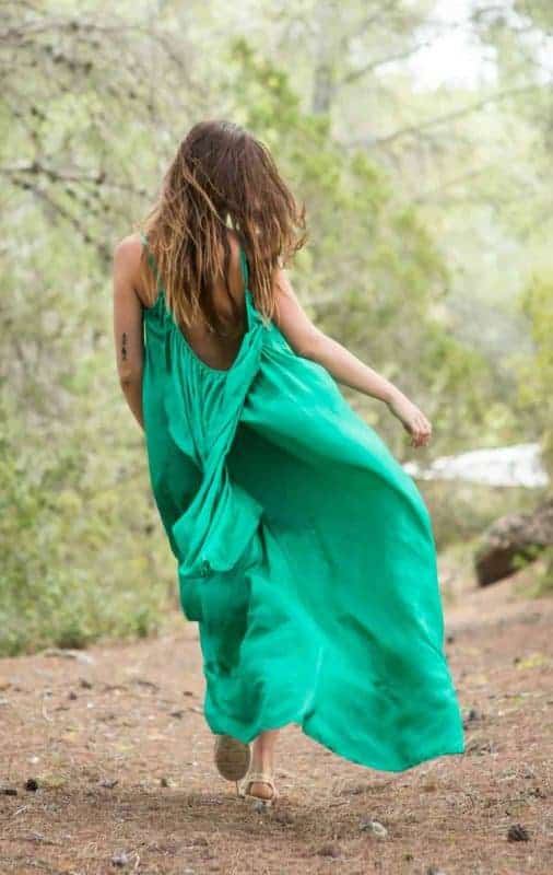 Skipping through a forest in a green silk dress