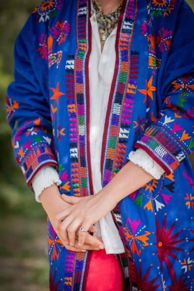 multicoloured embroidery on a blue wool coat