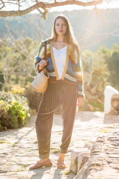 olive green trousers worn with a colourful striped cardigan