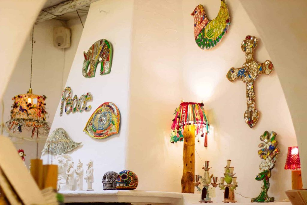 Colorful mosaic elephant wall art and decorative cross in La Galeria Elefante, showcasing vibrant Mexican folk art and handcrafted adornments.