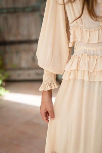 ruffle detail around the waist of a cream coloured dress