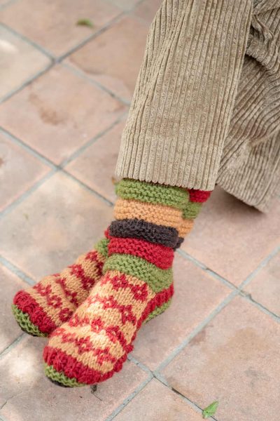 multicoloured woolly socks peeping out of corduroy trousers