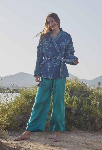 Model wearing green silk satin trousers with an indigo jacket with tie