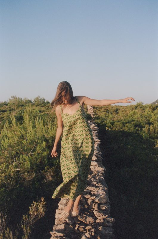 Model wears a strappy cotton floor length dress in a green print