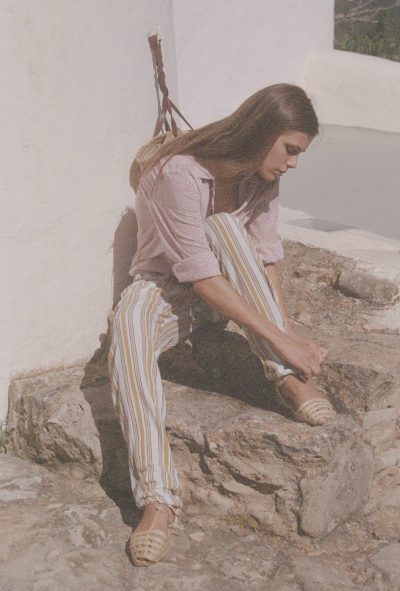 Model wearing yellow and white striped trousers with a pink and white spotty block print cotton shirt
