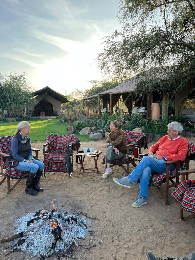 Relaxed outdoor gathering at featuring traditional plaid chairs and a cozy campfire in a scenic desert landscape.