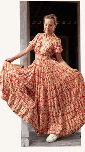 La Galeria Elefante Ibiza Woman in vibrant bohemian dress with floral pattern, Ibiza style, artisan fashion.