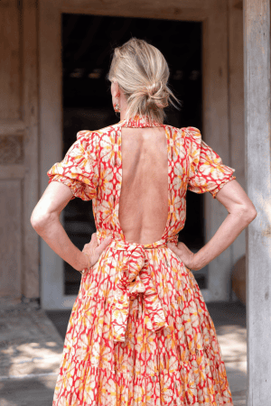 La Galeria Elefante Ibiza Woman wearing a vibrant, bohemian cotton dress with open back and colorful pattern.