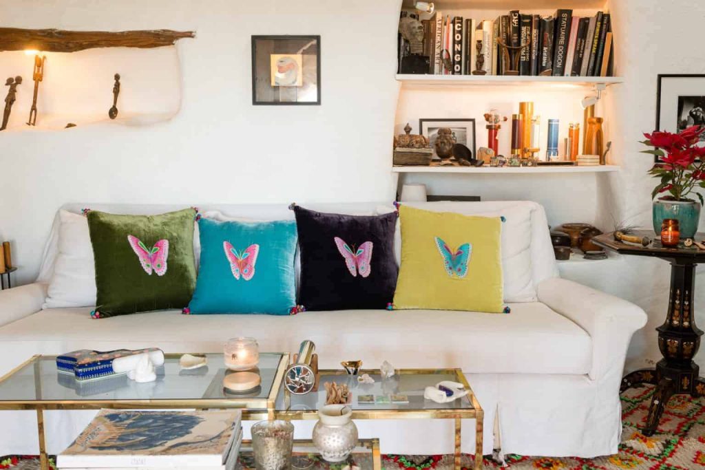 Cosy living room at La Galeria Elefante White elegant sofa with colourful cushions with embroidered butterflys on them