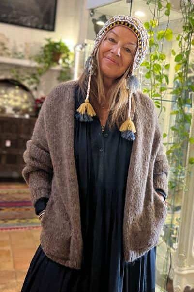 Colorful beanie hat and cozy cardigan worn by woman in a vibrant art gallery setting at La Galeria Elefante NGOs
