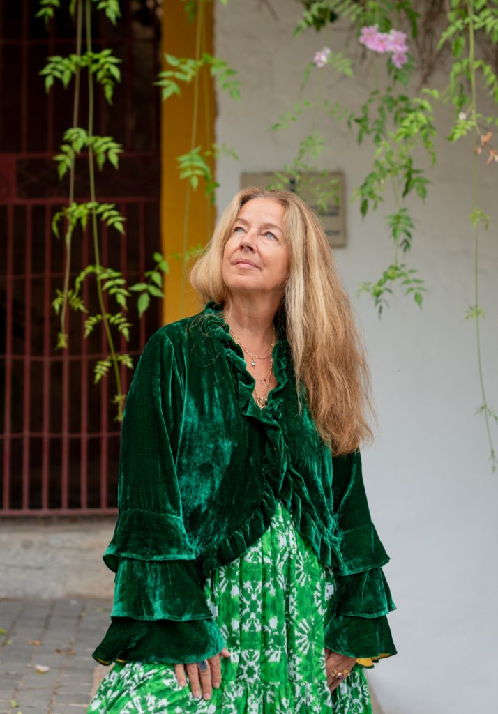 La Galeria Elefante Ibiza Woman in vibrant green velvet dress and bohemian style, Ibiza fashion, artisan clothing.
