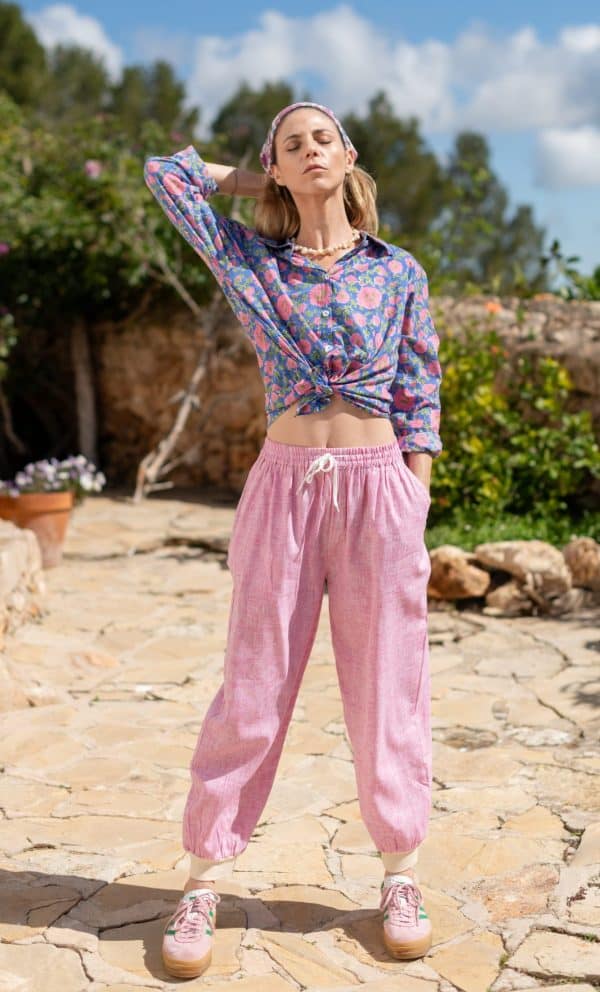 La Galeria Elefante Ibiza Young woman in colorful bohemian outfit outdoors with blue sky and greenery.