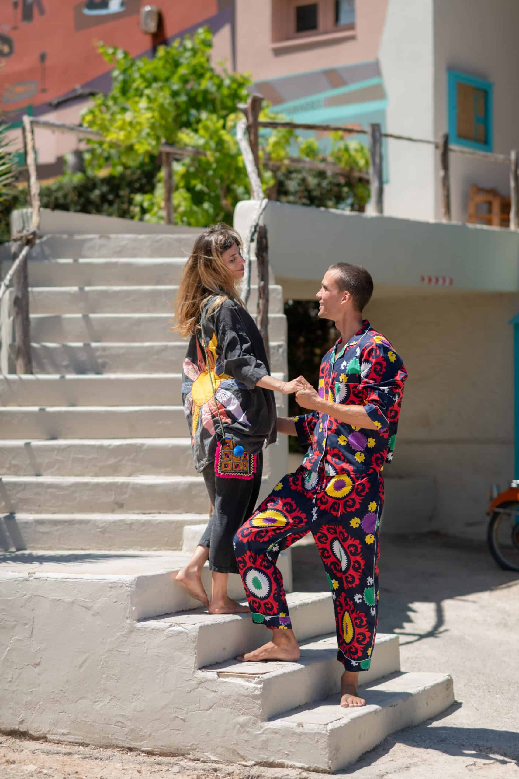 La Galeria Elefante Ibiza Two women with colorful bohemian clothing chatting on outdoor stairs in Ibiza.